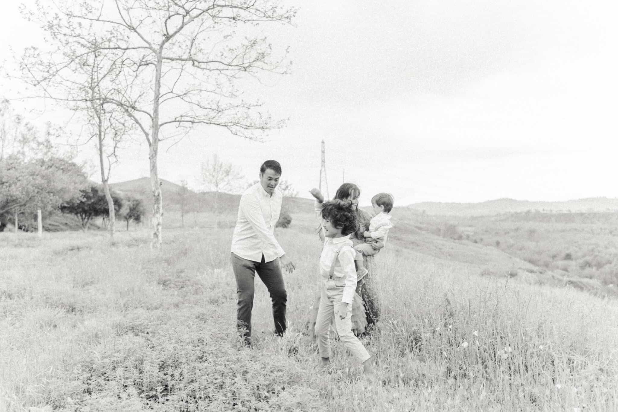 Black and white image of family dancing in an open field
