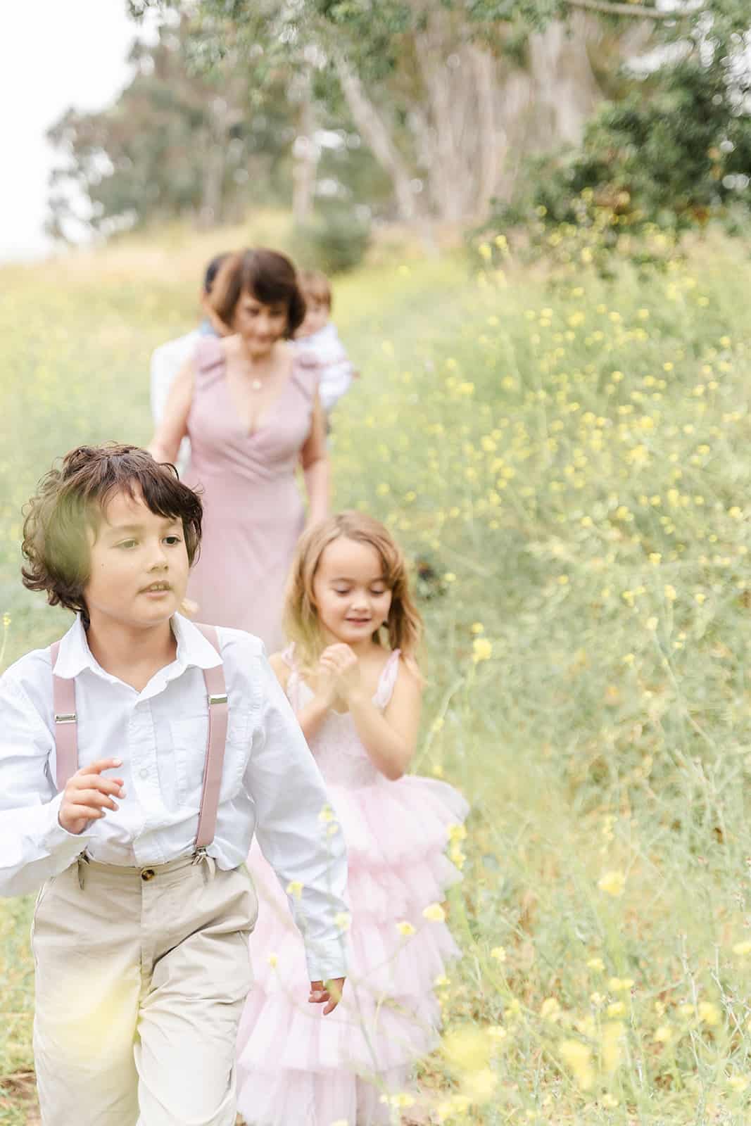 LePort Montessori Irvine students walk through a field of wildflowers with mom and dad behind them