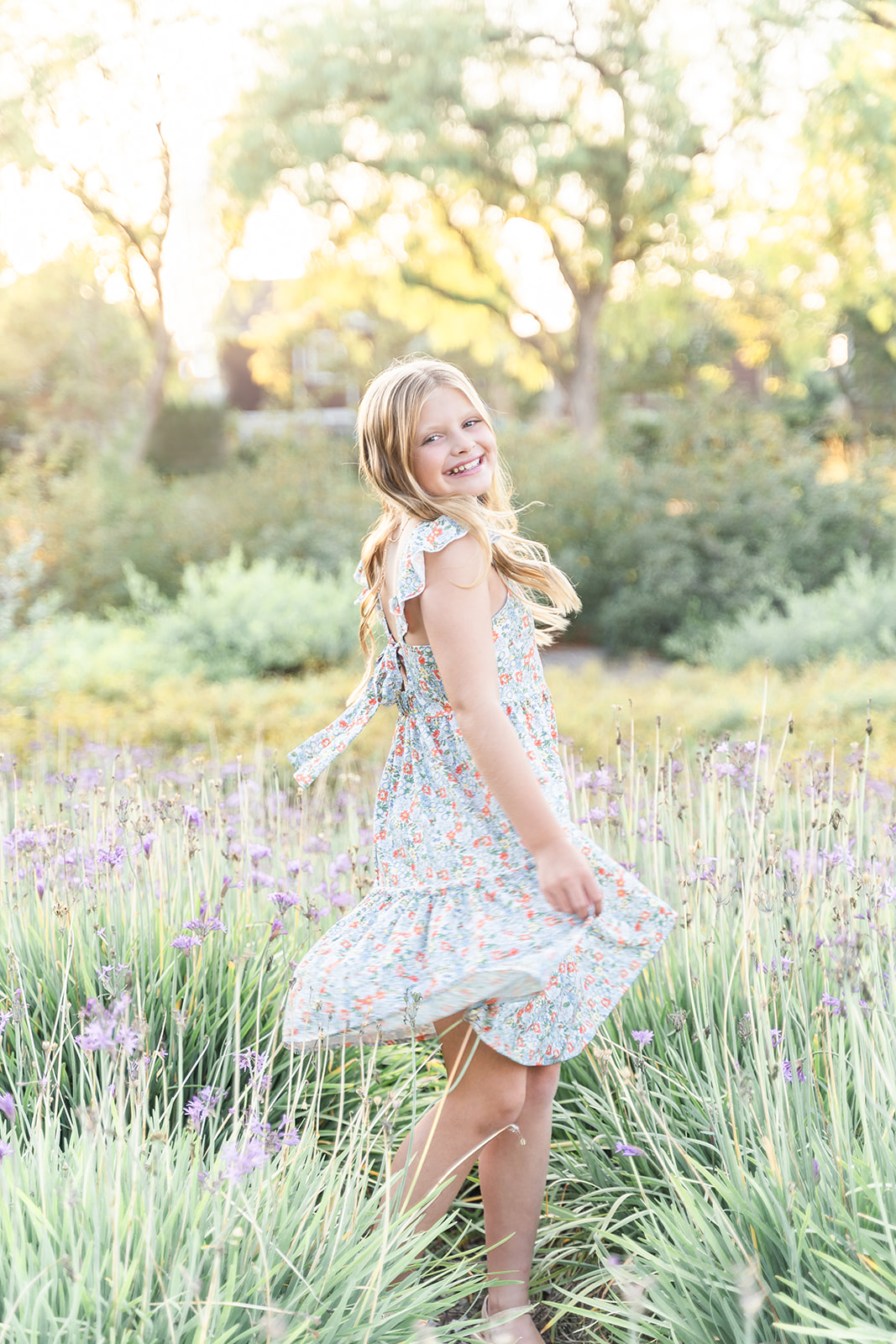 A teenage girl twirls and dances in a garden of purple flowers after attending Toddler Activities Orange County