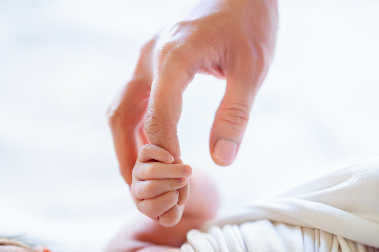 Details of a newborn baby's hand holding mom's finger before visiting The Rinks Irvine